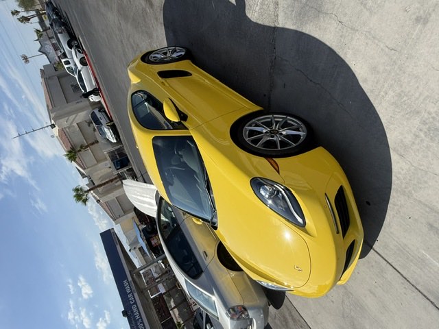 A yellow Porsche 718 Cayman parked at the shop.