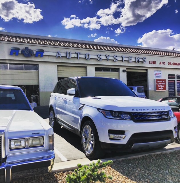 A Range Rover Sport and a Lincoln Town Car parked outside the R&R Auto Systems bays.