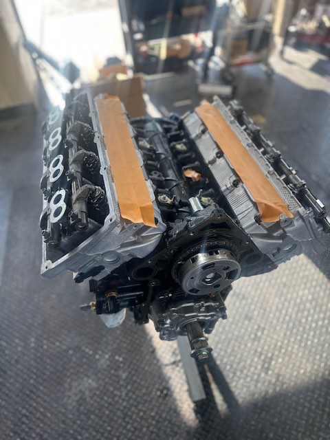 A V8 short block on a stand with the cylinder heads removed and the ports masked off.